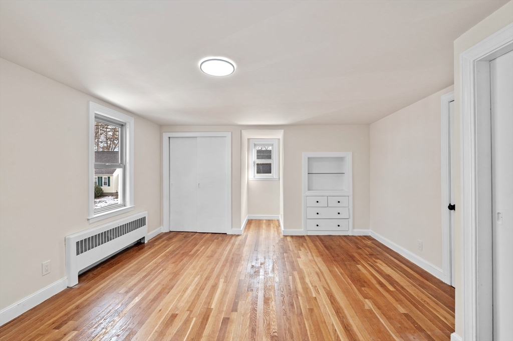 98 John Carver Road Reading, MA 01867 - Photo 26 of 40 a view of a big room with wooden floor and windows