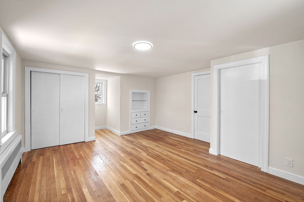 98 John Carver Road Reading, MA 01867 - Photo 27 of 40 a view of an empty room with wooden floor and a window