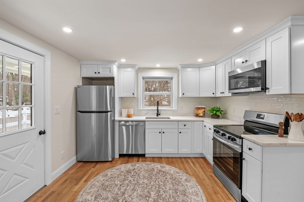 98 John Carver Road Reading, MA 01867 - Photo 4 of 40 a kitchen with a refrigerator a stove a microwave and cabinets