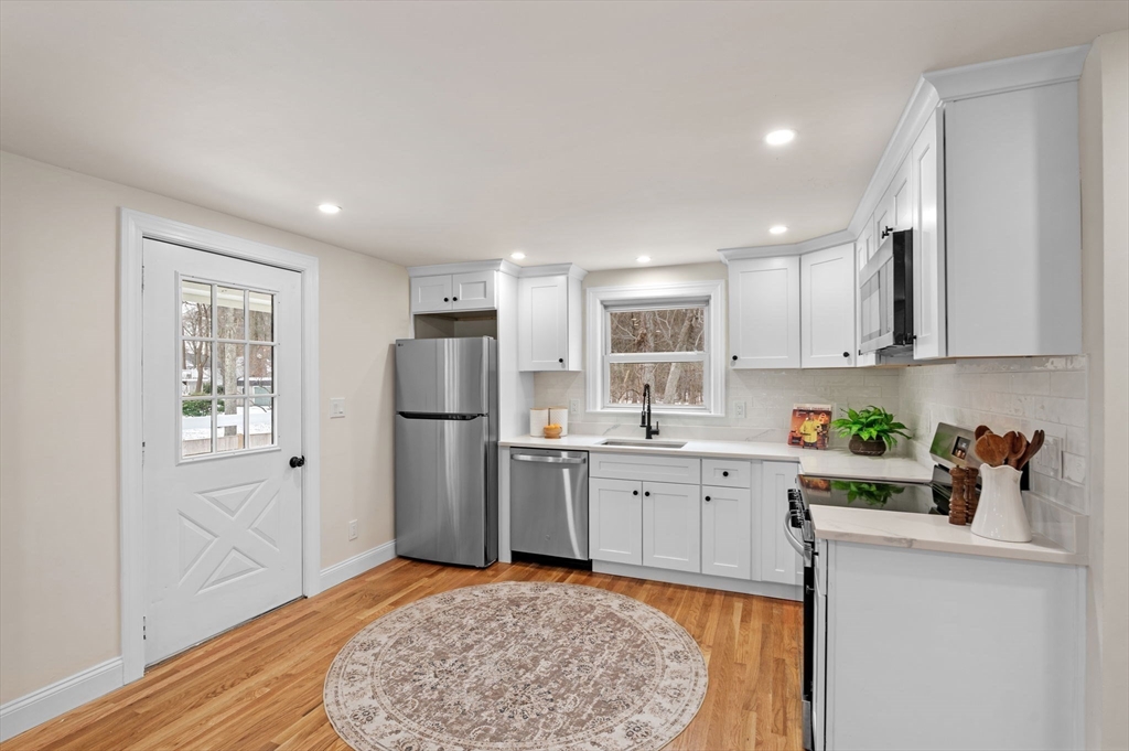 98 John Carver Road Reading, MA 01867 - Photo 5 of 40 a kitchen with a sink cabinets stainless steel appliances and a window