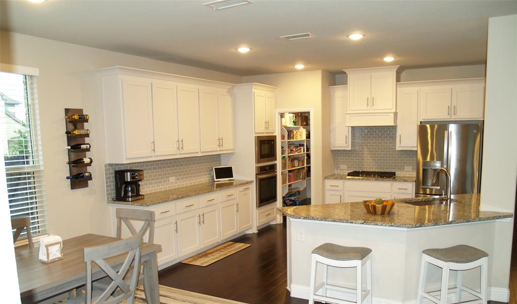 2104 Vista Ridge Road Melissa, TX 75454 - Photo 11 of 40 a kitchen with stainless steel appliances kitchen island granite countertop a sink and cabinets