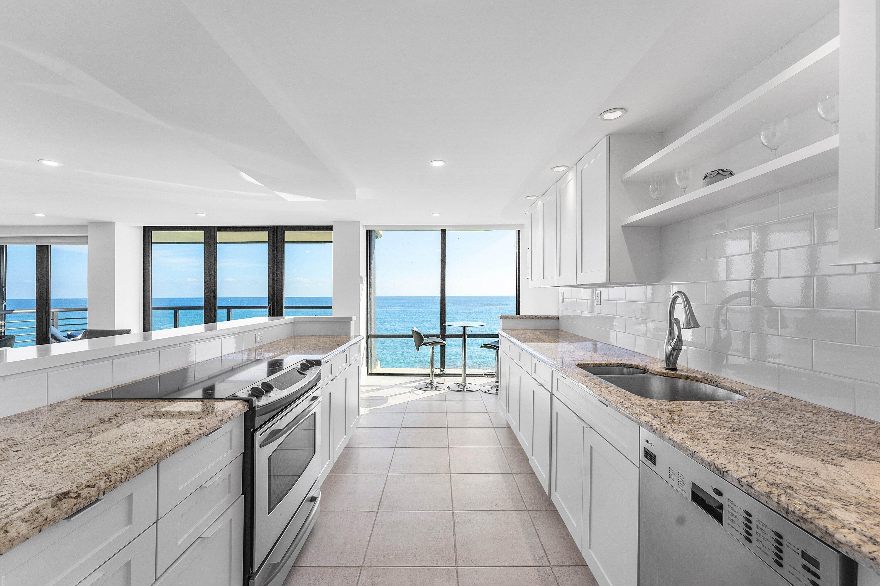 250 South Ocean Boulevard, Unit 4F Boca Raton, FL 33432 - Photo 14 of 45 a large kitchen with granite countertop a sink and a stove