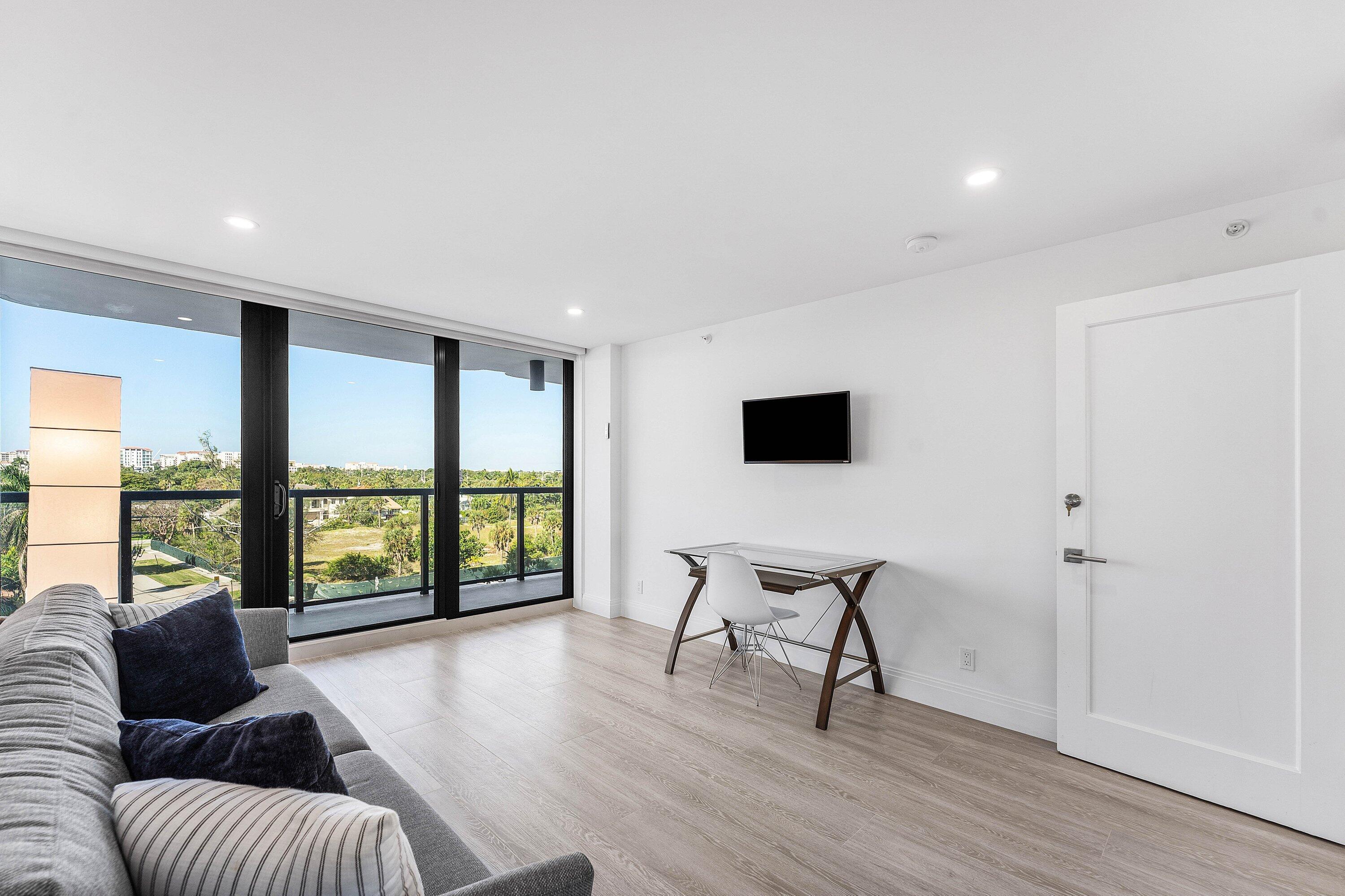 250 South Ocean Boulevard, Unit 4F Boca Raton, FL 33432 - Photo 24 of 45 a living room with furniture and a flat screen tv with wooden floor