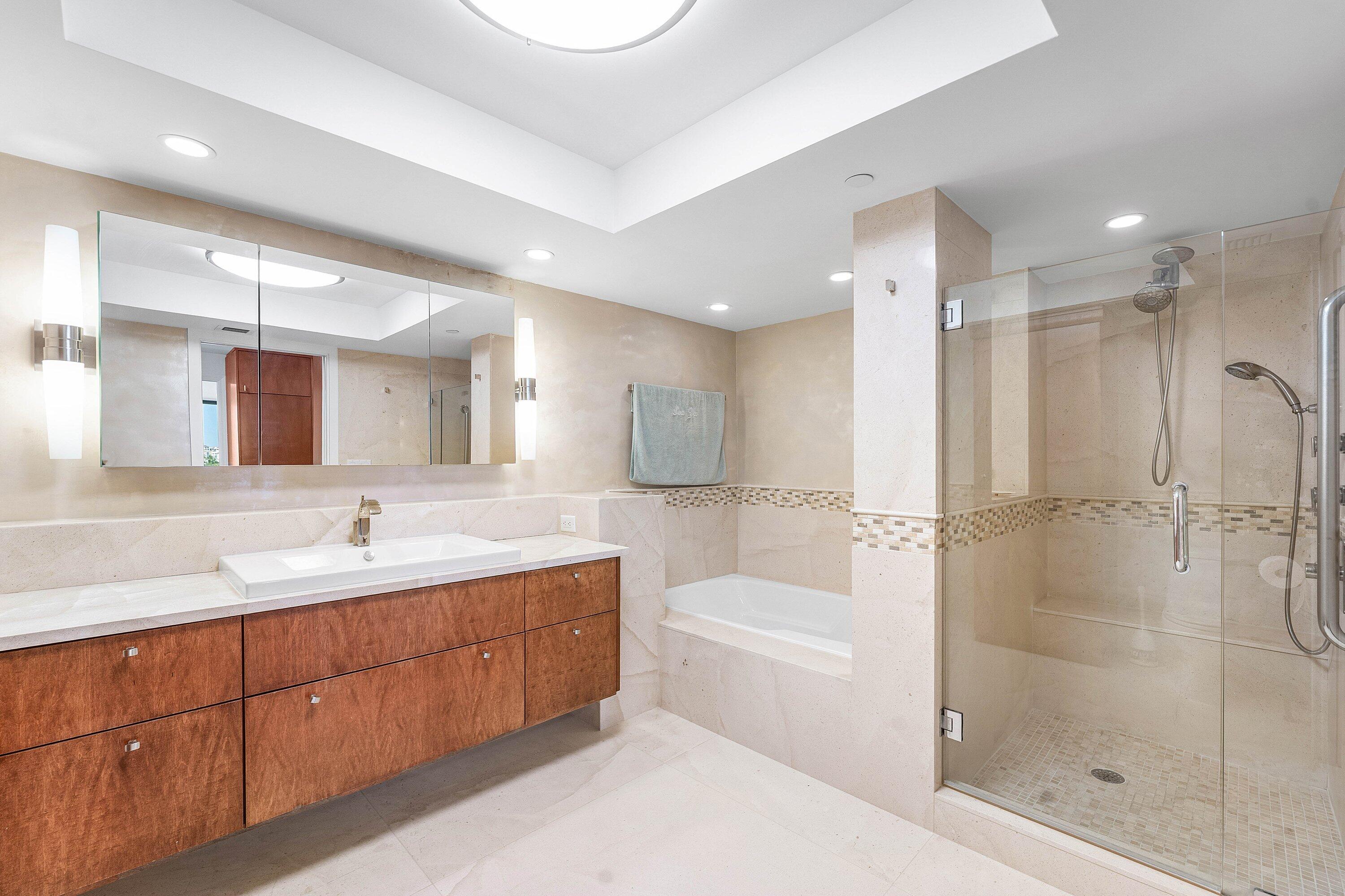 250 South Ocean Boulevard, Unit 4F Boca Raton, FL 33432 - Photo 31 of 45 a bathroom with a bathtub shower sink vanity and mirror