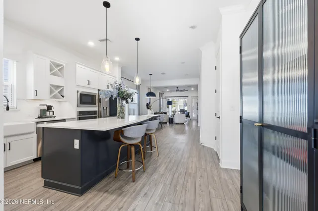 a kitchen with stainless steel appliances kitchen island a table chairs microwave and refrigerator