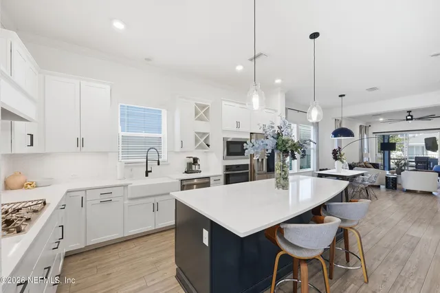 a kitchen with stainless steel appliances a dining table chairs stove and cabinets