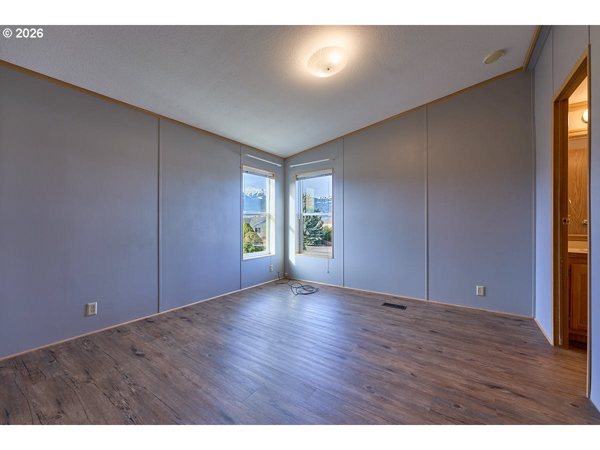 801 Residence Street Enterprise, OR 97828 - Photo 13 of 20 a view of an empty room with wooden floor and a window