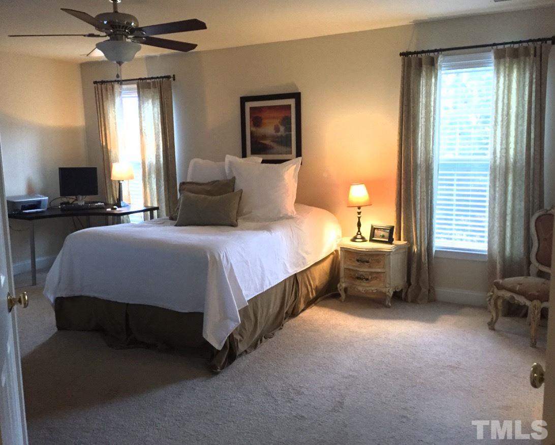 9525 Vira Drive Raleigh, NC 27617 - Photo 11 of 13 a bedroom with a bed and a chandelier