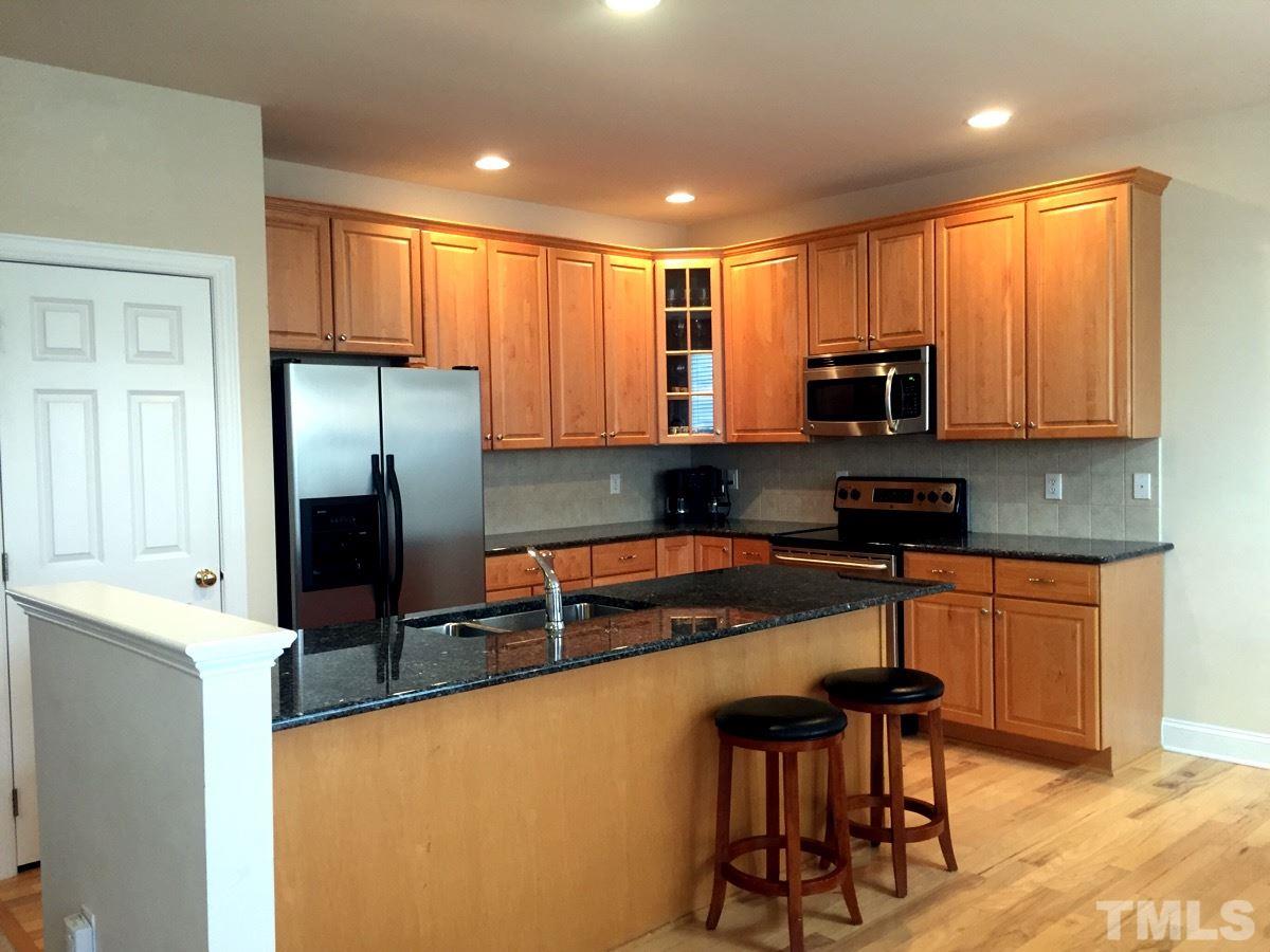 9525 Vira Drive Raleigh, NC 27617 - Photo 4 of 13 a kitchen with stainless steel appliances granite countertop a refrigerator a stove top oven a sink and dishwasher