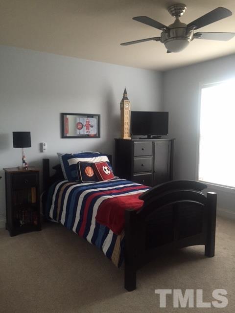 9525 Vira Drive Raleigh, NC 27617 - Photo 8 of 13 a bedroom with a bed and a chandelier