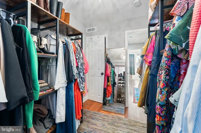 a view of walk in closet with clothes and shoes