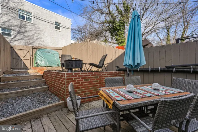 a view of a patio with table and chairs with wooden floor and fence