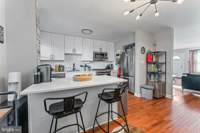 a view of kitchen with stainless steel appliances granite countertop a dining table and chairs