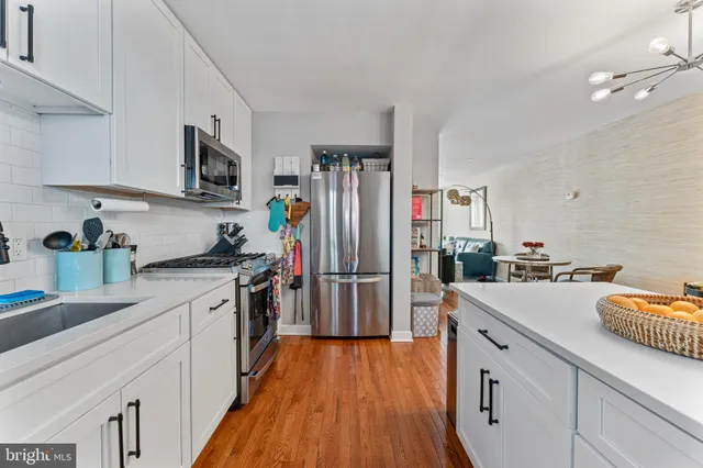 a kitchen with a sink dishwasher a refrigerator a stove and wooden floors