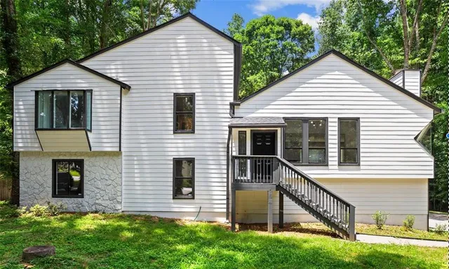 a view of house with a yard and a large window