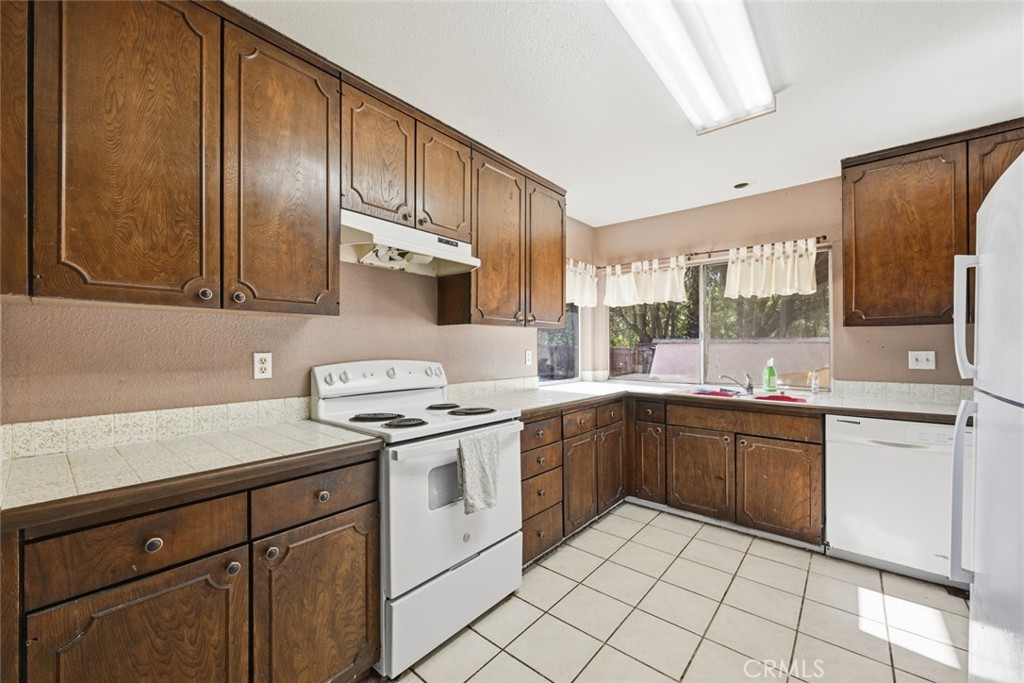 2202 Village Road Escondido, CA 92026 - Photo 5 of 15 a kitchen with a stove sink and cabinets