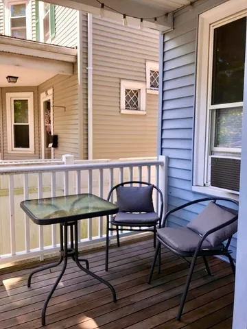 a view of a balcony with wooden floor and fence