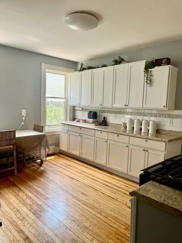 a kitchen with sink a microwave and cabinets