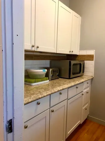 a kitchen with a stove and white cabinets