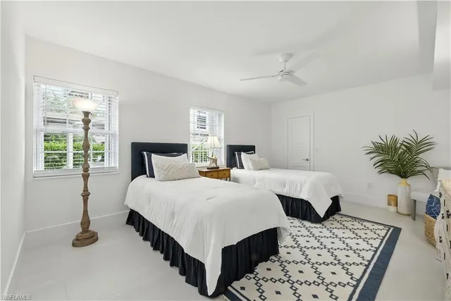 a spacious bedroom with two beds and a potted plant