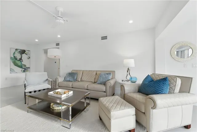 a living room with furniture a rug and a chandelier