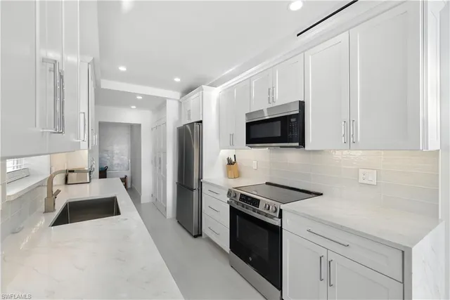 a kitchen with stainless steel appliances a stove microwave and sink
