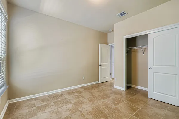 an empty room with closet and entryway