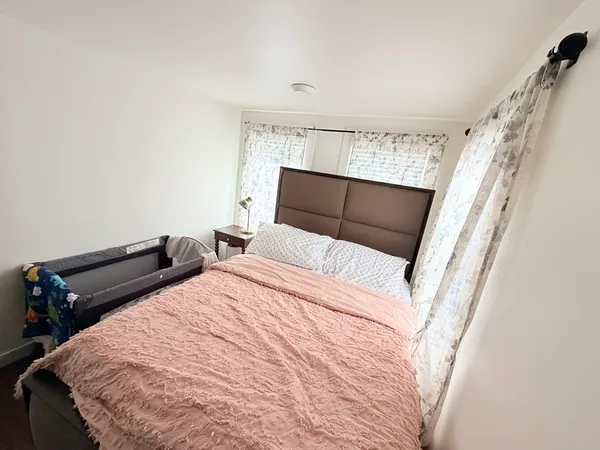 a bedroom with a bed and wooden floor