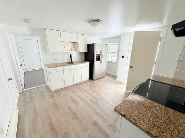 a kitchen with a sink a refrigerator and cabinets