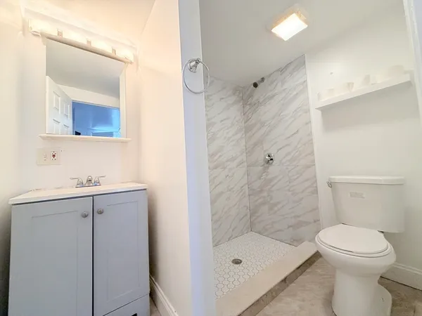 a bathroom with a sink a toilet and shower