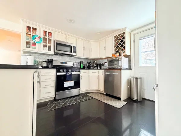 a kitchen with stainless steel appliances granite countertop a refrigerator a stove top oven a sink and dishwasher
