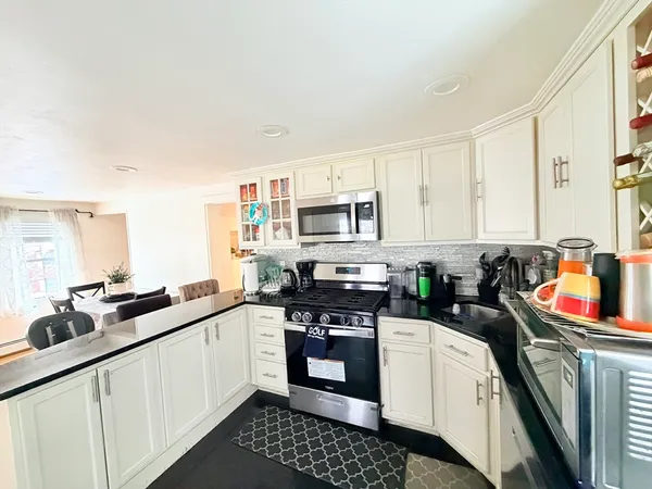 a kitchen with stainless steel appliances a sink stove and cabinets