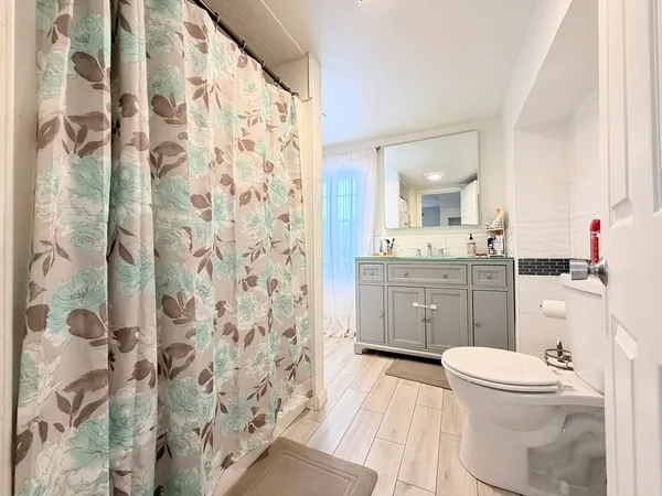 a bathroom with a sink toilet vanity and shower