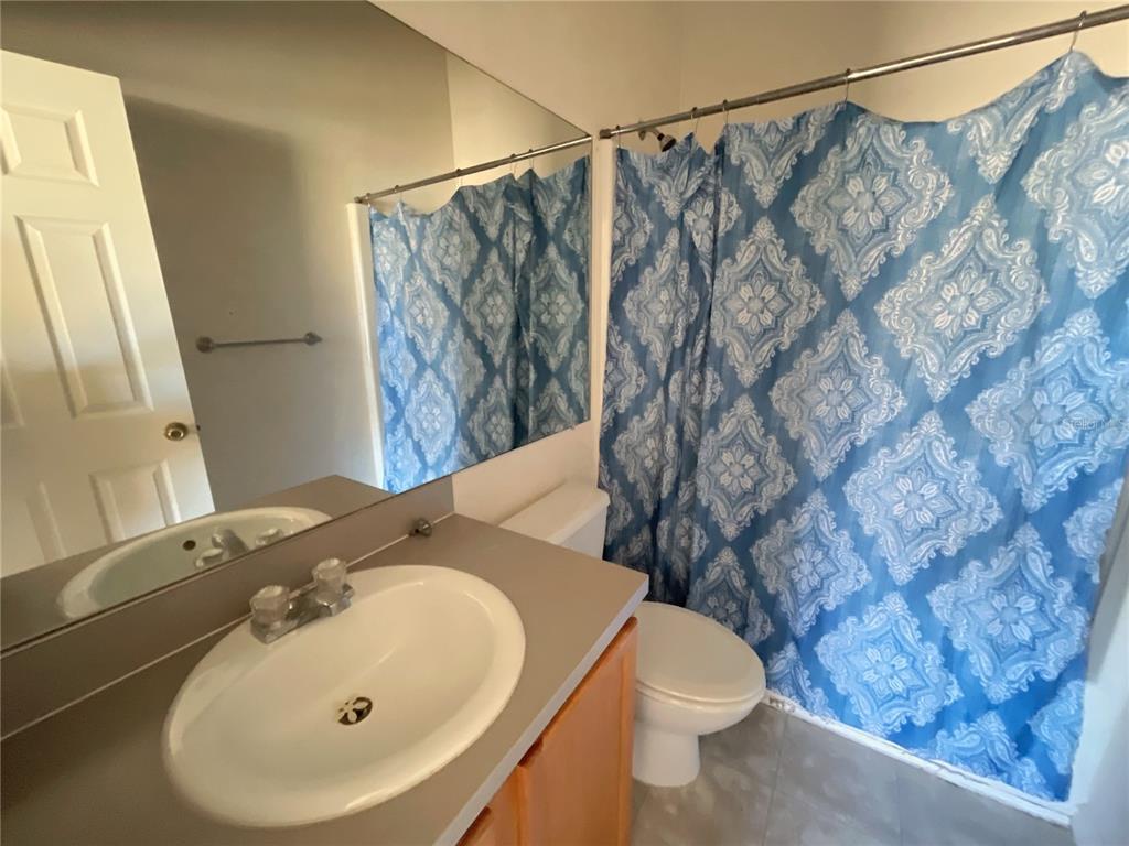 3930 Southwest 20th Avenue, Unit 1902 Gainesville, FL 32607 - Photo 11 of 15 a bathroom with a sink and mirror with toilet