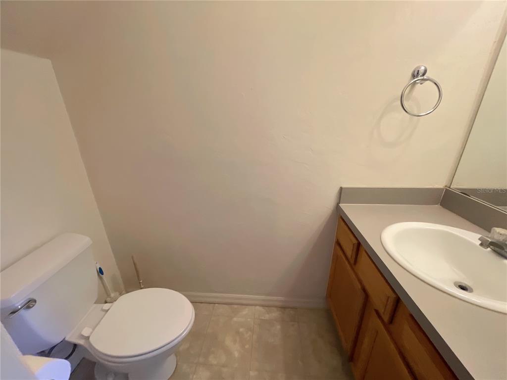 3930 Southwest 20th Avenue, Unit 1902 Gainesville, FL 32607 - Photo 13 of 15 a bathroom with a granite countertop sink toilet and a mirror