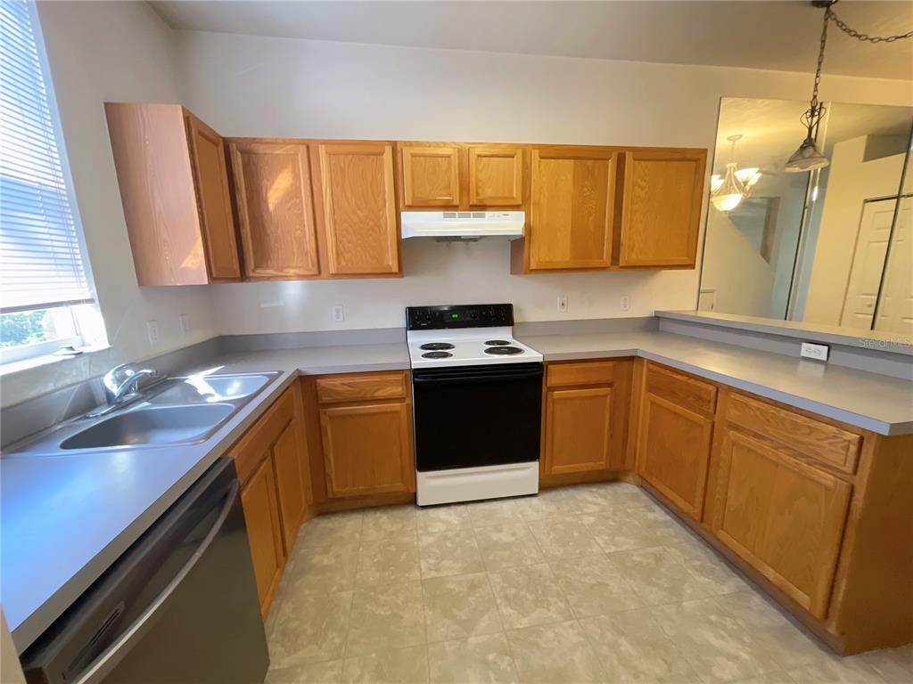 3930 Southwest 20th Avenue, Unit 1902 Gainesville, FL 32607 - Photo 4 of 15 a kitchen with a sink stove top oven and cabinets