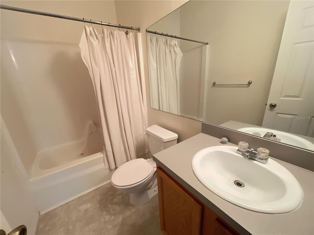 3930 Southwest 20th Avenue, Unit 1902 Gainesville, FL 32607 - Photo 5 of 15 a bathroom with a sink a toilet and shower
