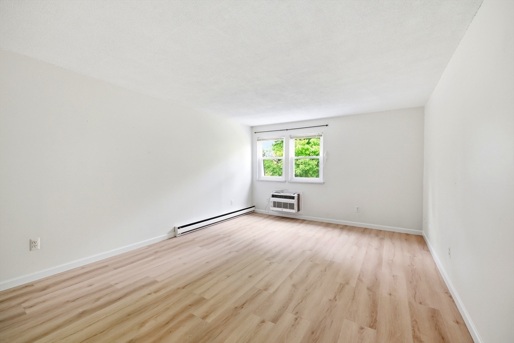 80 Damon Road, Unit 2303 Northampton, MA 01060 - Photo 15 of 23 an empty room with a hardwood and windows