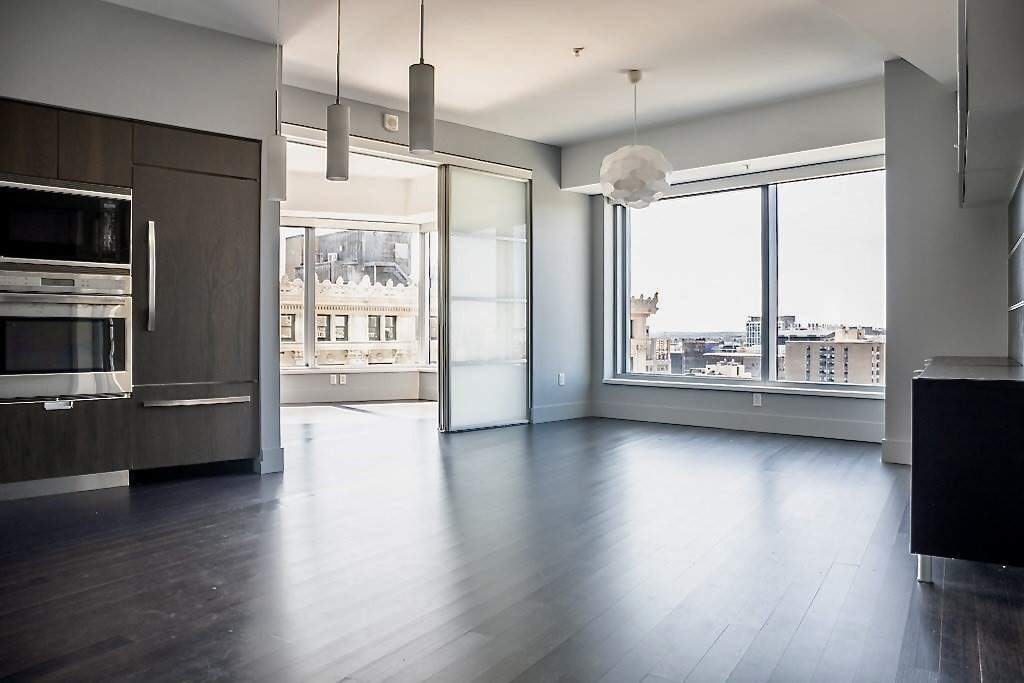 110 Stuart Street, Unit 16H Boston, MA 02116 - Photo 2 of 18 a view of an empty room with wooden floor and a window