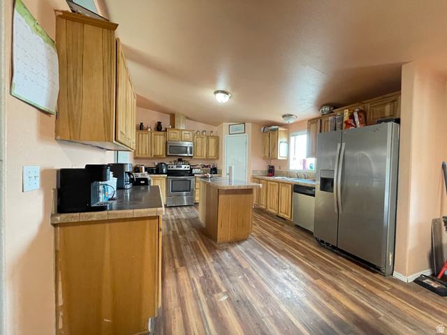 240 Horseshoe Bend Road Vernal, UT 84078 - Photo 8 of 41 Kitchen featuring stainless steel appliances, a center island, lofted ceiling, dark wood finished floors, and tile countertops