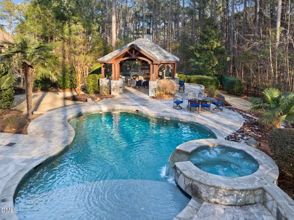 a view of a swimming pool with lawn chairs under an umbrella