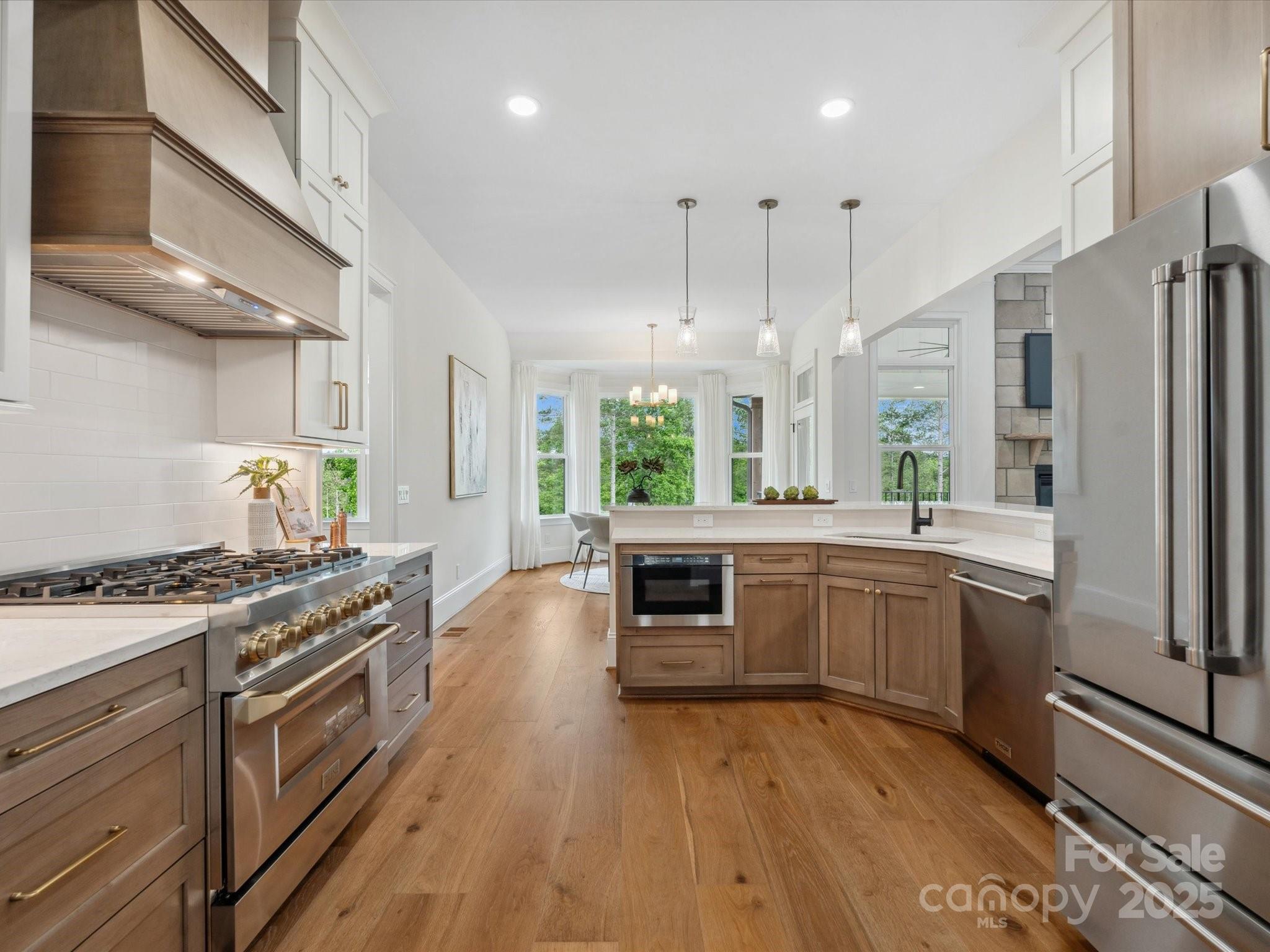 2024 Jumping Run Connelly Springs, NC 28612 - Photo 12 of 48 a kitchen with stainless steel appliances granite countertop a stove a sink dishwasher and a refrigerator with wooden floor