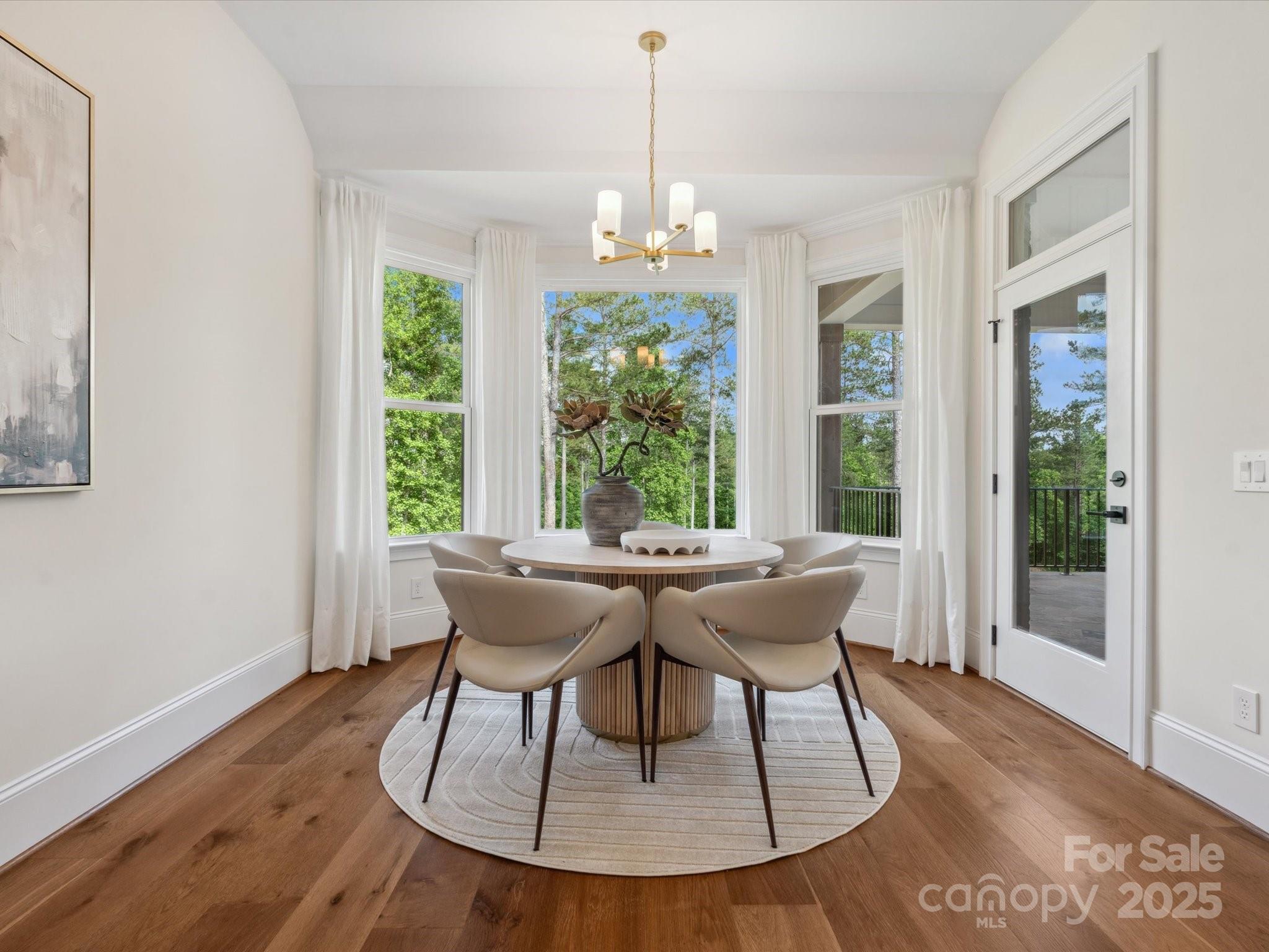 2024 Jumping Run Connelly Springs, NC 28612 - Photo 20 of 48 a dining room with wooden floor a chandelier a glass table and chairs