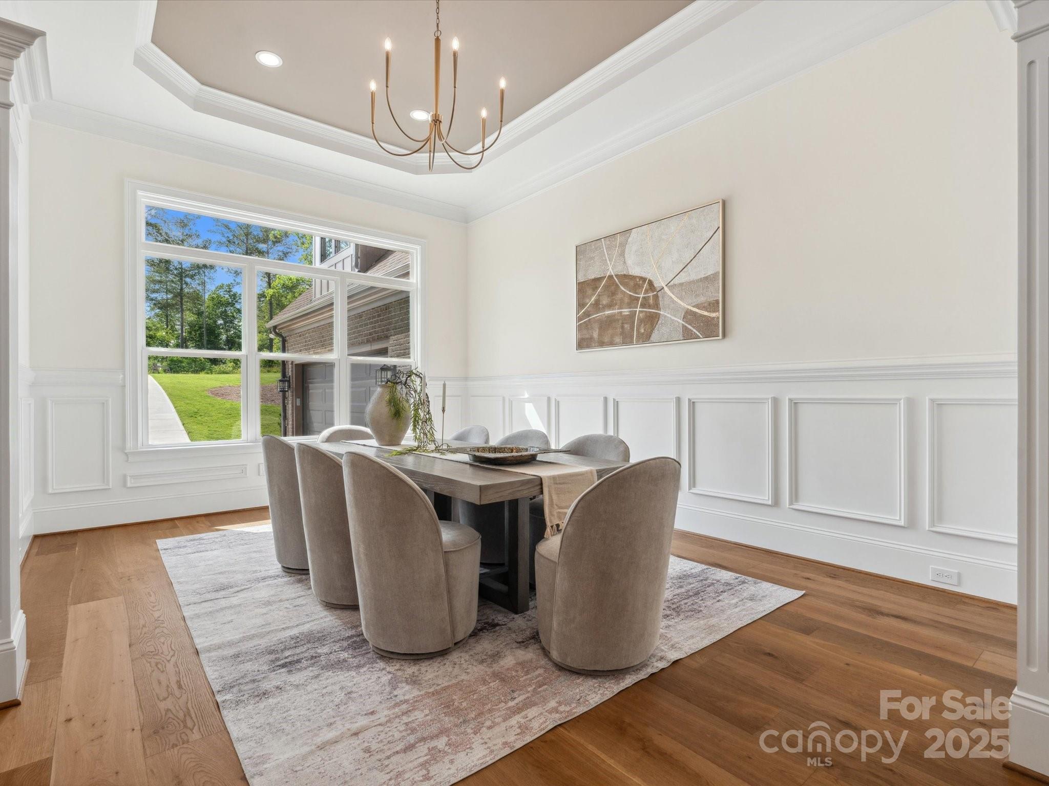 2024 Jumping Run Connelly Springs, NC 28612 - Photo 22 of 48 a dining room with wooden floor and a chandelier