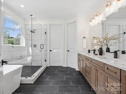 a spacious bathroom with a double vanity sink a large mirror a bathtub and shower