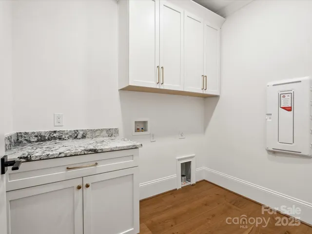 a kitchen with granite countertop white cabinets and white appliances