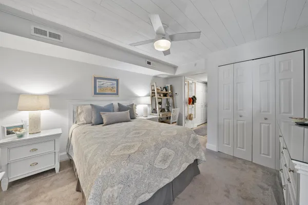 a bedroom with a large bed and a flat tv screen on dresser