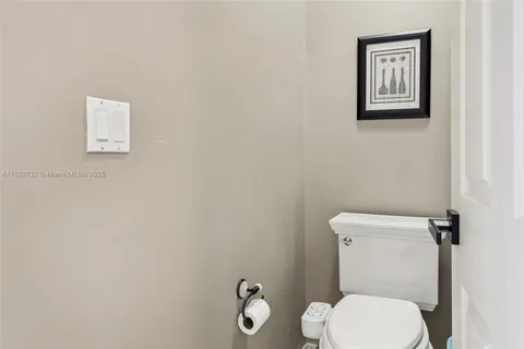 a view of a white house next to a yard with a fountain