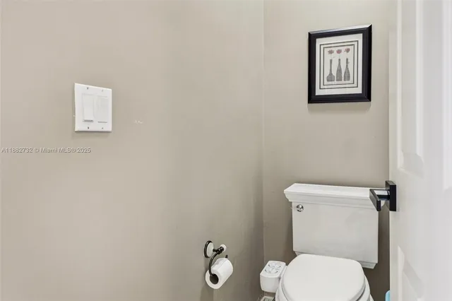 a view of a white house next to a yard with a fountain