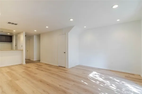 an empty room with windows and fireplace